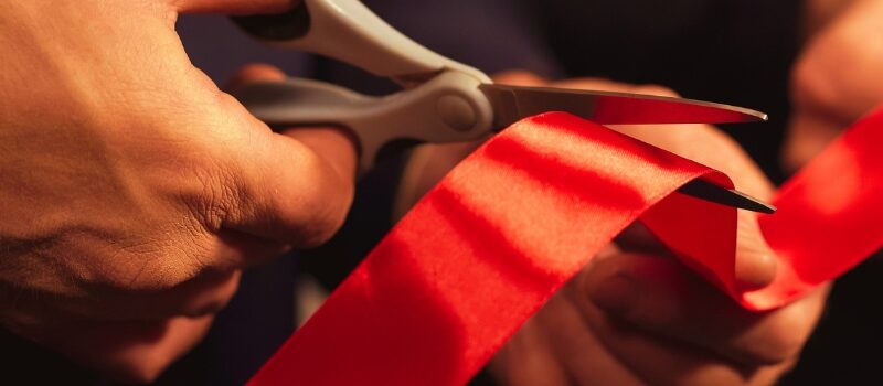 Business people hands cutting red ribbon close-up, new project, opening ceremony