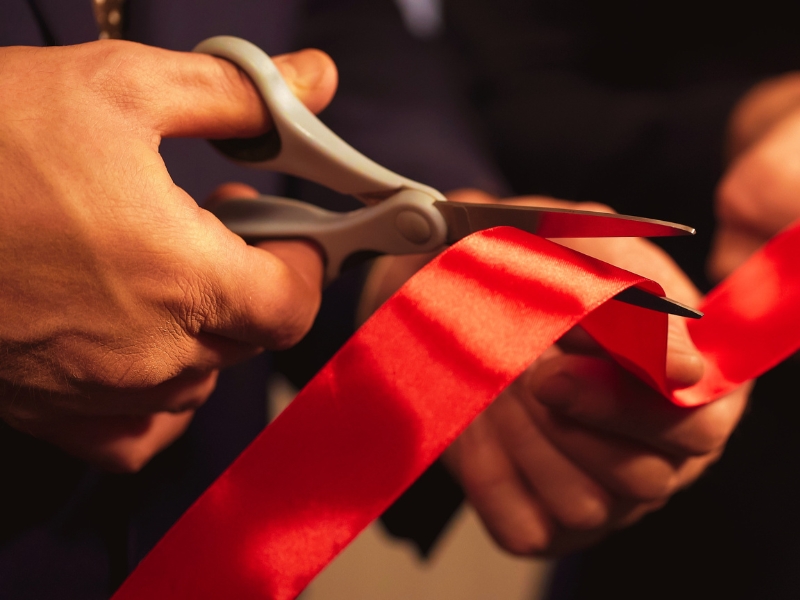 Business people hands cutting red ribbon close-up, new project, opening ceremony
