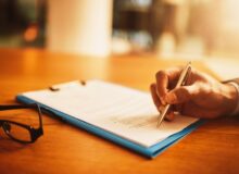 Lawyer hand showing paperwork for signing, agreement contract and settlement offer in law firm office