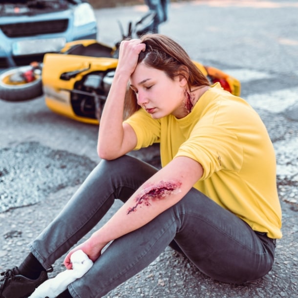 Woman on road after car accident