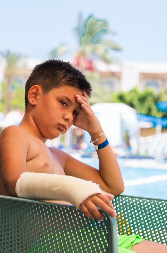 Boy with broken arm after slip and fall at swimming pool