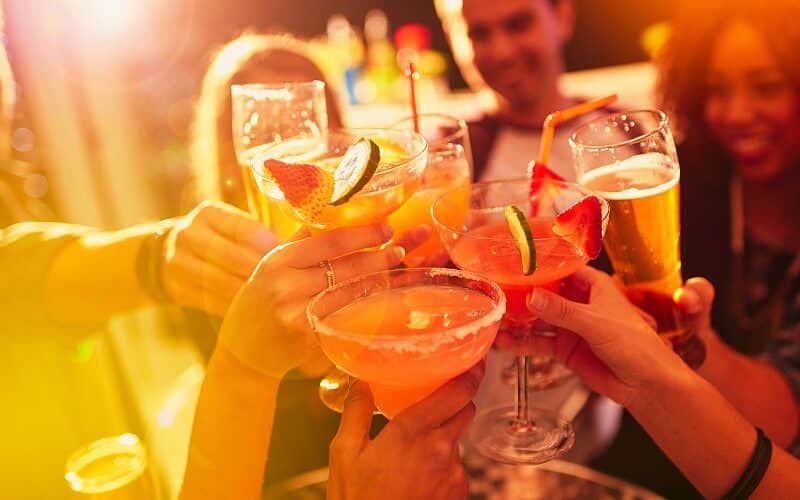 Shot of a group of people toasting with their drinks at a nightclub