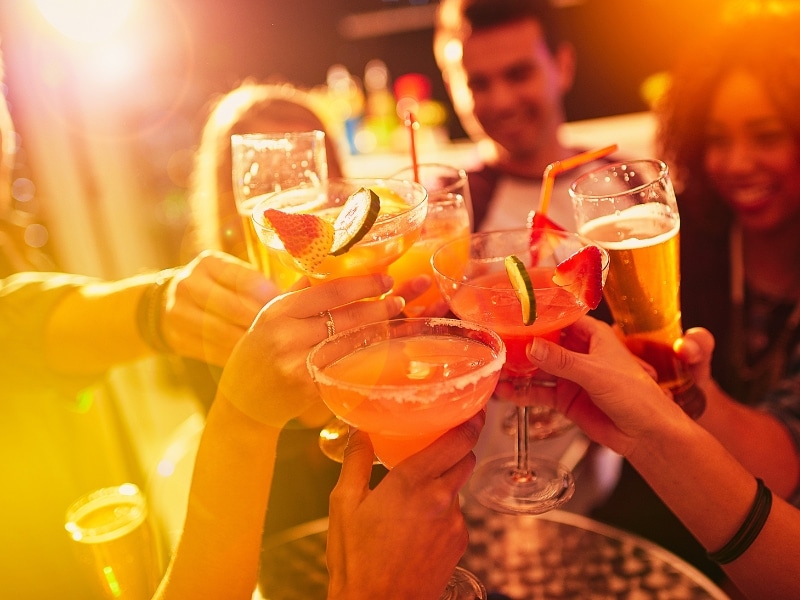 Shot of a group of people toasting with their drinks at a nightclub