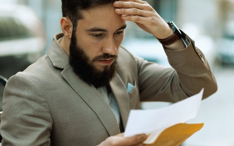 A shocked man reads a court letter