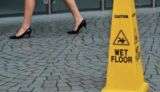 Slippery floor surface warning sign and symbol in building. Concept of how much is a slip and fall worth in Palm Harbor