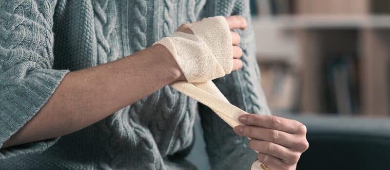 Injured woman hands removing bandage from arm. Concept of What the New Florida Comparative Fault Reform Means for Your Personal Injury Case 1