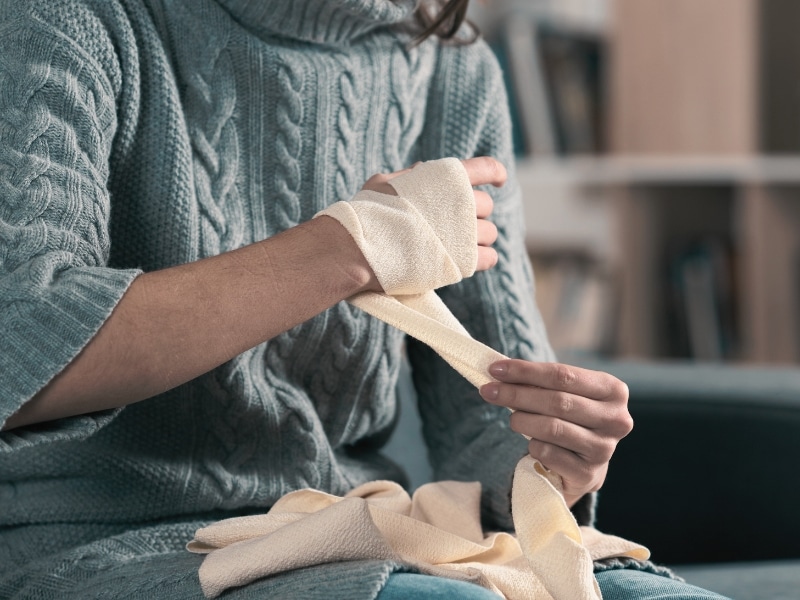 Injured woman hands removing bandage from arm. Concept of What the New Florida Comparative Fault Reform Means for Your Personal Injury Case 1