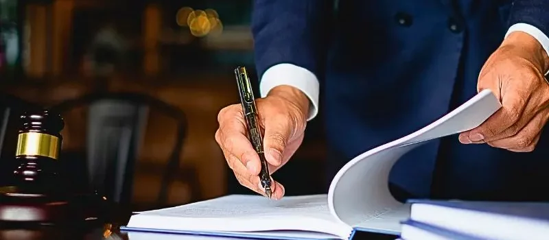 Close up lawyer businessman working or reading lawbook in office workplace. When to Get a Personal Injury Lawyer