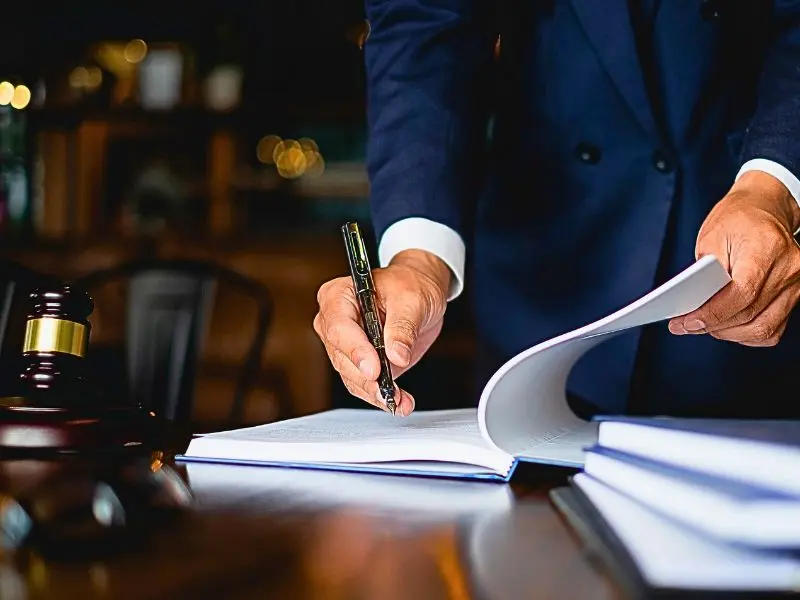 Close up lawyer businessman working or reading lawbook in office workplace. When to Get a Personal Injury Lawyer