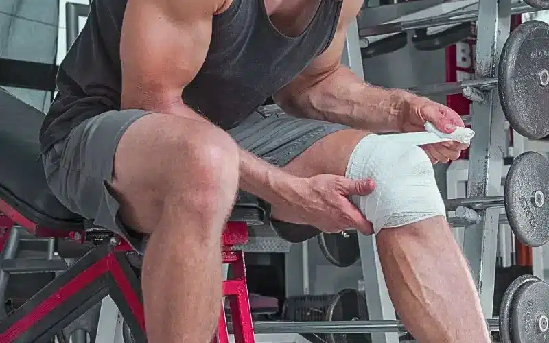Muscular Caucasian man wraps knee with sport bandage in weightlifting gym. how many personal injury cases go to trial