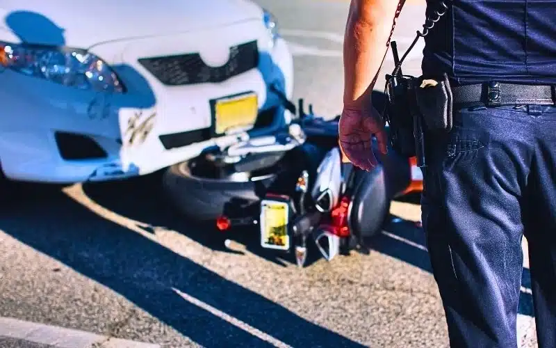 Police office at scene of an accident between a car and motorcycle. average compensation for a motorcycle accident