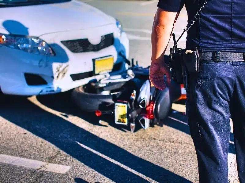 Police office at scene of an accident between a car and motorcycle. average compensation for a motorcycle accident