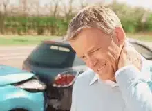 Man holding his neck looks like in pain due to car accident. how to sue after car accident