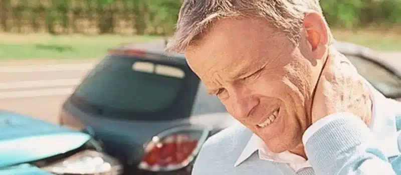Man holding his neck looks like in pain due to car accident. how to sue after car accident