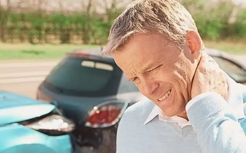 Man holding his neck looks like in pain due to car accident. how to sue after car accident