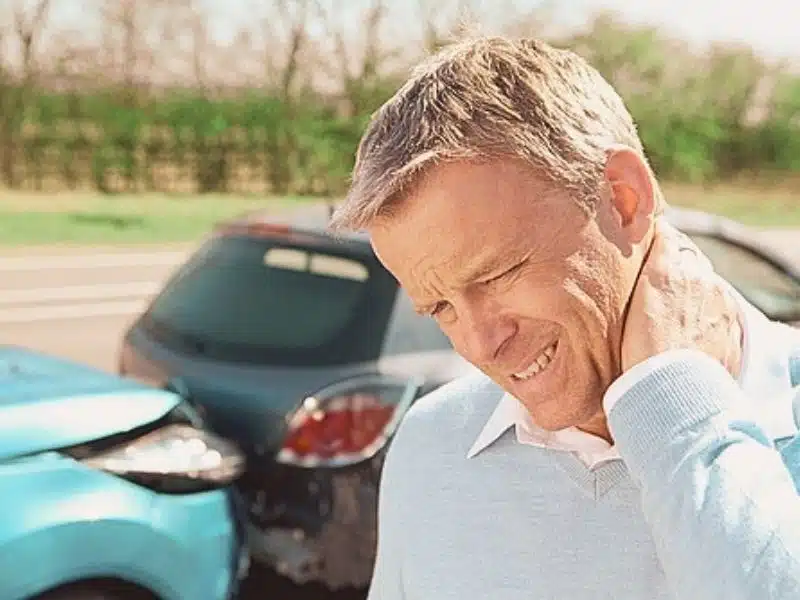 Man holding his neck looks like in pain due to car accident. how to sue after car accident