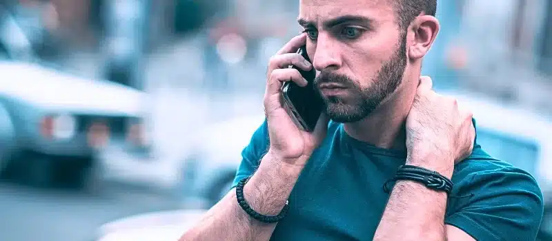 Frustrated man using his mobile phone.