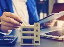 A woman calculating the value of a property.