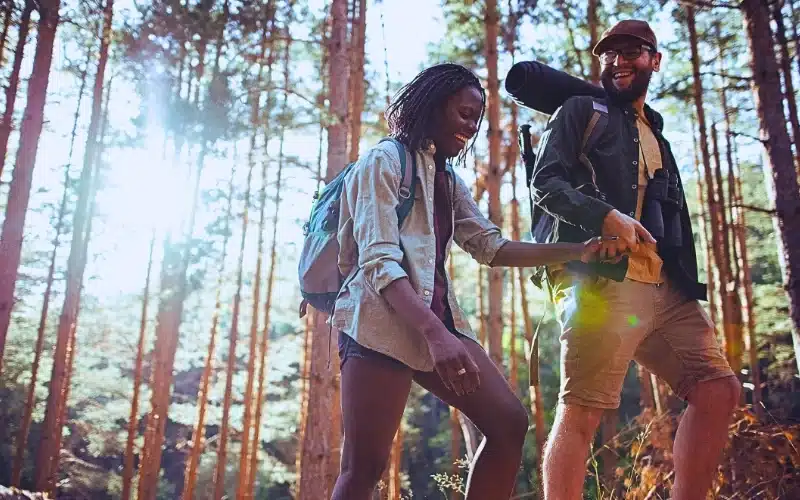 Happy couple hiking while holding hands.