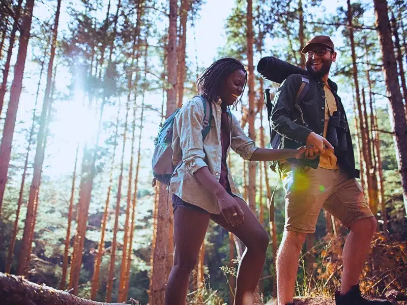 Happy couple hiking while holding hands.