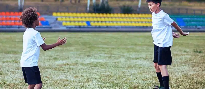 Two children playing football.
