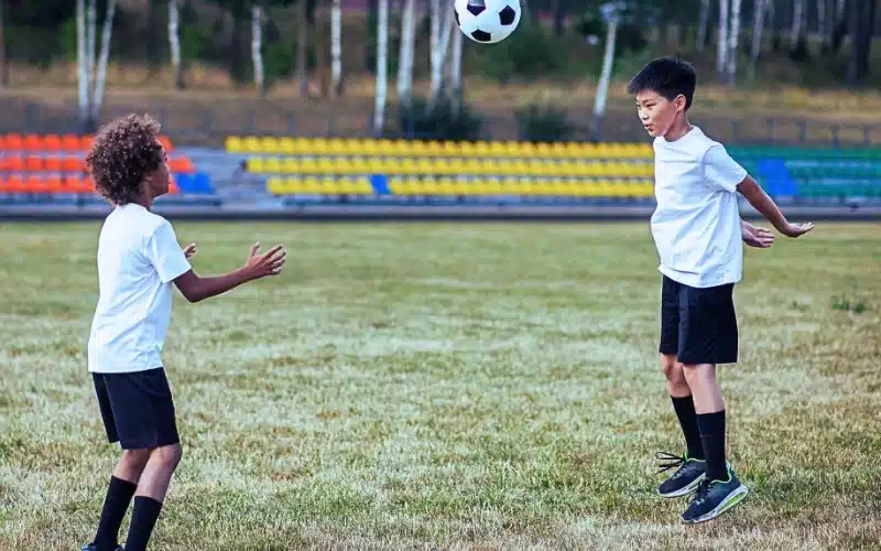Two children playing football.