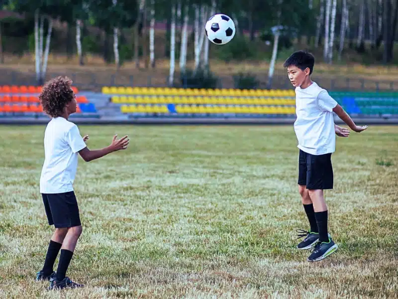 Two children playing football.