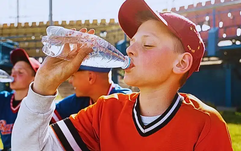 Side view kid drinking water.