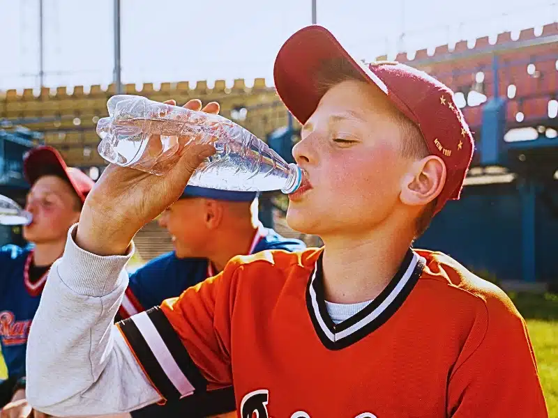 Side view kid drinking water.
