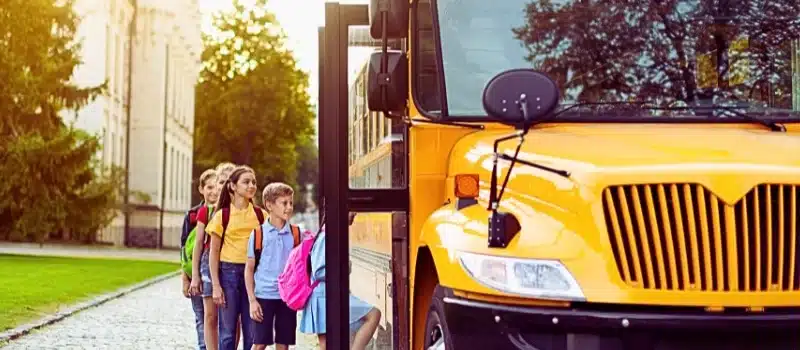 Group of children getting on the yellow school bus.