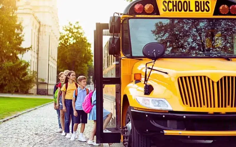 Group of children getting on the yellow school bus.