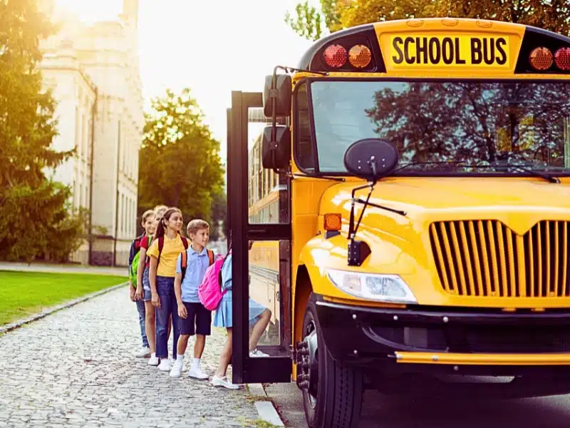 Group of children getting on the yellow school bus.