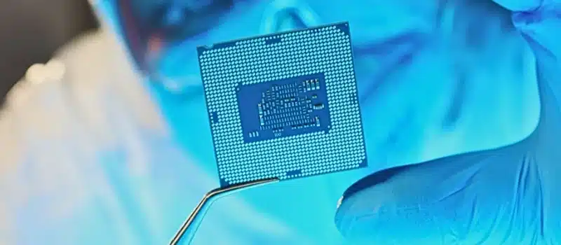 Scientist developer in protective suit holds microcircuit.